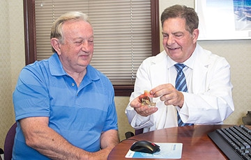 Doctor showing patient a model of a denture